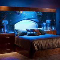 Большой аквариум над кроватью в спальной комнате
